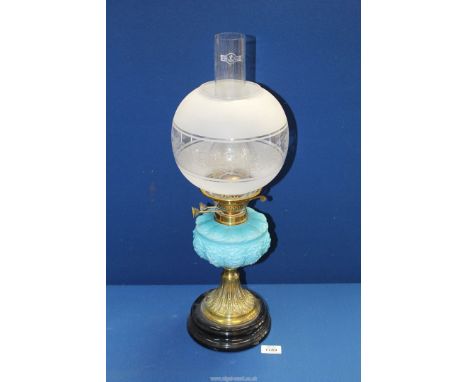 A ceramic and brass based oil lamp with turquoise glass reservoir, chimney and etched glass shade,  23" tall.
