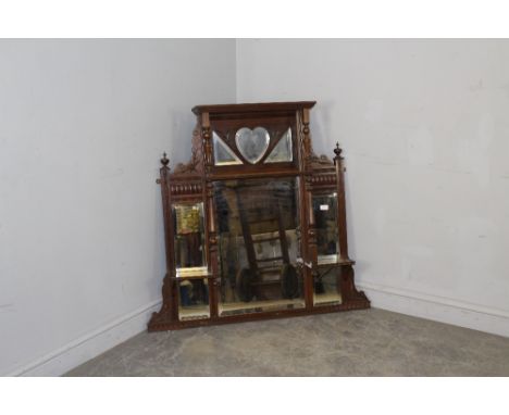 A late Victorian mahogany over-mantel mirror, with bevelled mirror plates, turned columns and carved detail 102cm x 108cm