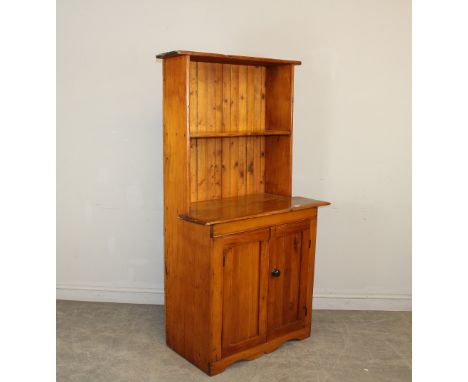 A country made yewwood dresser, the back with single shelf over the shaped top and two cupboard doors, on a shaped base rail 