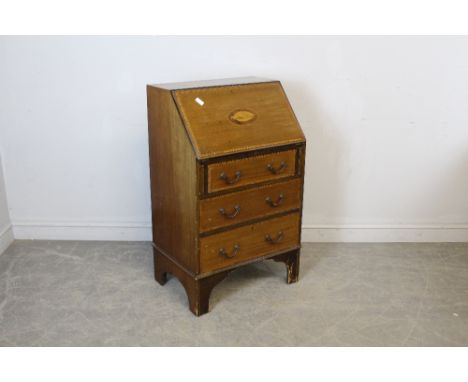 An Edwardian inalid mahogany bureau, of small proportions. The fall front inlaid with conch shell paterae over three drawers,