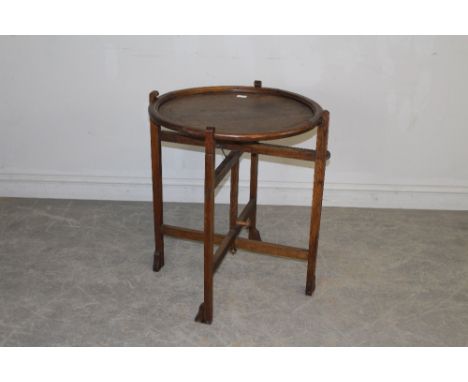 A 1930's oak 'Revertable' card table with circular top and folding base 72.5cm x 61cm