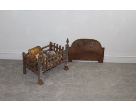 A cast-iron fire or dog grate with finial topped columns 44cm x 52cm x 32cm, sold along with a cast-iron arched fire back wit