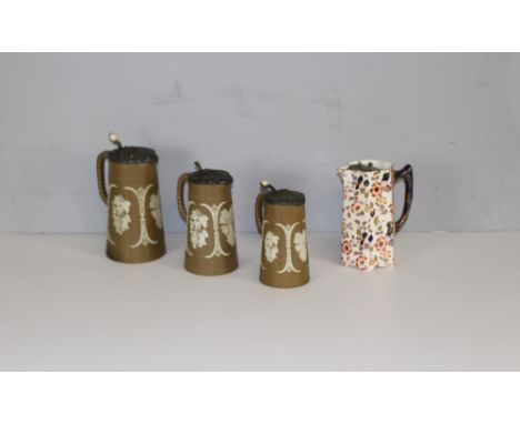 A set of Three Victorian graduating pottery jugs with pewter mounts, the buff bodies sprigged with seasonal crops 20cm (talle