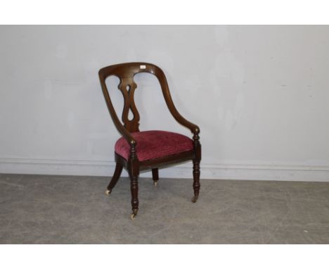 A Victorian mahogany armchair, with central vase-form supporting splat and down-swept arms over the padded seat, moulded seat