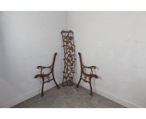 A cast and pierced-iron garden bench (AF) in the Victorian style with scrolled ends and bowed foliate back, lacking seat rail