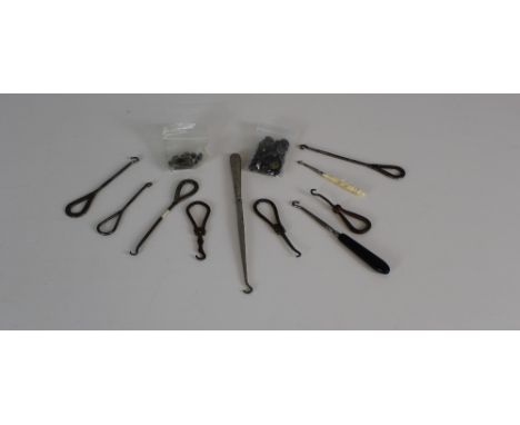 A collection of antique button hooks and two small packets of buttons