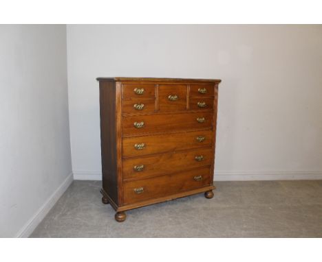 A mahogany 'Scotch' chest in the Victorian style with embossed brass back plates and bale handles, central hat drawer flanked