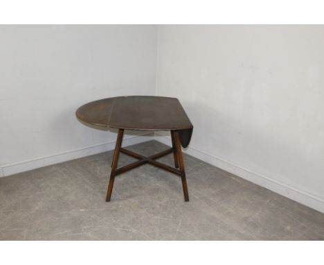 An Ercol Dark Elm circular drop-leaf table, with X-form stretcher 70cm x 124cm extended x 113cm