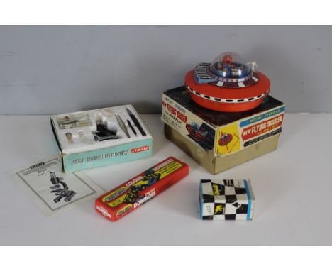 A vintage tin plate battery operated Flying saucer, in original card packaging, a Merit (J&amp;L Randall Ltd) Microscope set 