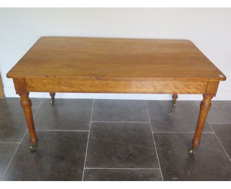 A 19th century satinwood table with two long drawers both stamped Holland and Sons with a later pine top, was possibly a libr