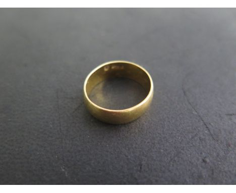 A 22ct yellow gold hallmarked band ring, size N, approx 5.8 grams, some usage marks but generally good 