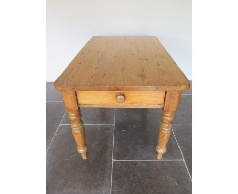 A Victorian stripped pine kitchen table with an end drawer on turned legs with a 3cm thick top, 77cm tall x 132cm x 79cm 