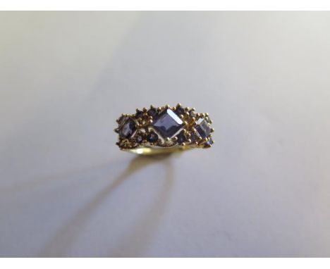 A hallmarked 9ct gold amethyst ring set with three square cut stones surrounded by 12 small round cut stones, size P/Q, appro