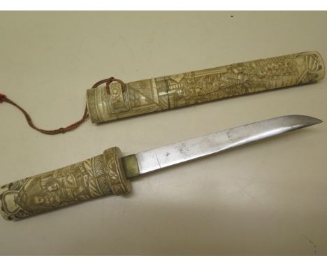 A 20th century carved bone Japanese dagger, 39cm long, generally good ,roundal missing to one end, crack to scabbard 