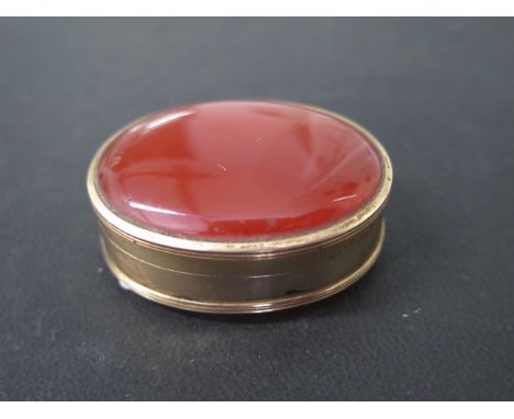 A gilt metal carnelian oval snuff pill box, 45mm x 33mm x 19mm tall, in good condition, shuts well, total weight approx 31 gr