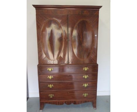 A Georgian mahogany linen press with two door top enclosing a slide and a shelf above a four drawer base, 213cm tall x 127cm 
