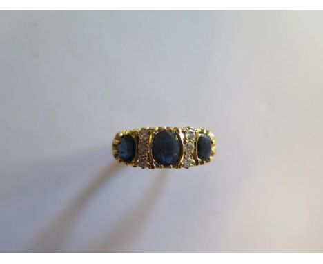 A hallmarked 18ct yellow gold  sapphire and diamond ring, size R, approx 8.3 grams, the central sapphire approx 6mm x 5mm x 2