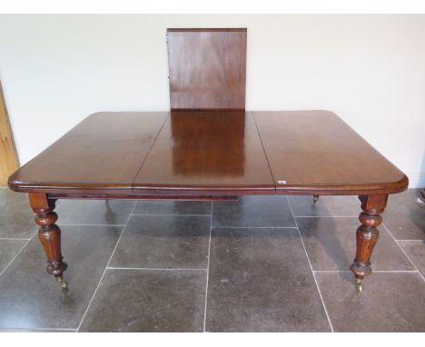 A 19th century mahogany pullout dining table with two leaves on turned carved legs, 71cm tall x 126cm wide, extends from 120c