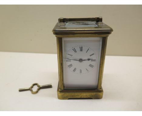 A brass carriage clock striking on a gong, 13cm tall, glass good, running with key 