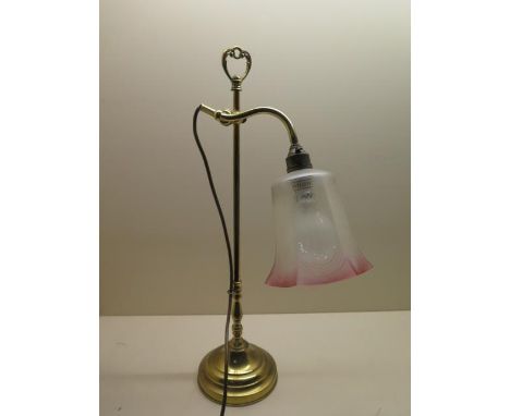 A brass adjustable desk lamp with a cranberry tinted shade, in generally good condition, working 