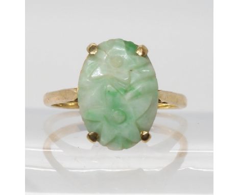 A 9ct gold Chinese green hardstone ring, carved with flowers. Dimensions of the stone 16.1mm x 11.6mm, finger&nbsp; size T1/2