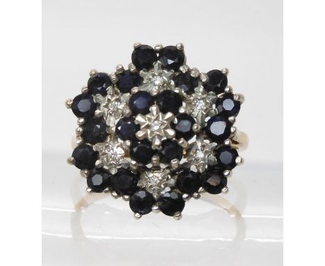 A 9ct sapphire and diamond accent flower cluster ring, size Q1/2, diameter approx 2cm, weight 4.8gms One sapphire has a chip,