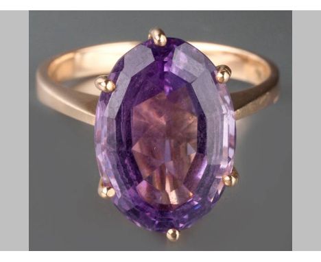 A 9CT YELLOW GOLD AND AMETHYST RING, oval form amethyst claw set on a solid shank, 4.8g.