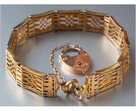 A 9CT YELLOW GOLD GATE BRACELET, ending in a heart-shaped lock, complete with safety chain, 19cm long, 21.1g.