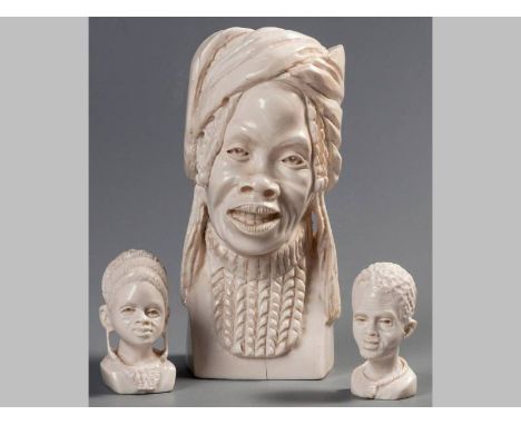 A CARVED IVORY BUST OF AN AFRICAN WOMAN, wearing a head scarf, 20cm high. Together with two smaller examples, 7.5cm and 8cm h