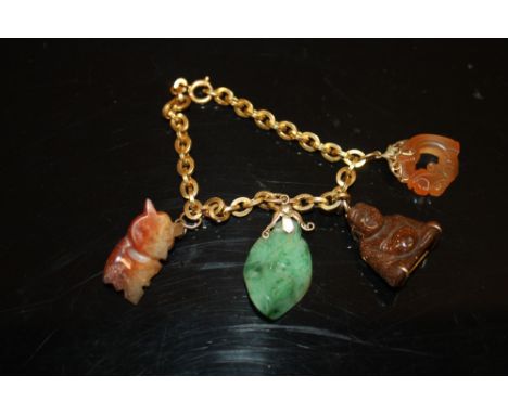 A CHINESE / ORIENTAL 18K GOLD CHARM BRACELET WITH CARVED HARD STONE CHARMS TO INCLUDE A JADE EXAMPLE APPROX WEIGHT - 26G 