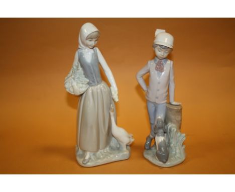 TWO NAO FIGURES OF A BOY WITH A DOG AN A GIRL WITH A GOOSE 