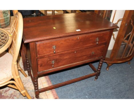 A SMALL OAK TWO DRAWER CHEST WITH BOBBIN SUPPORTS H-79 CM W-92 CM