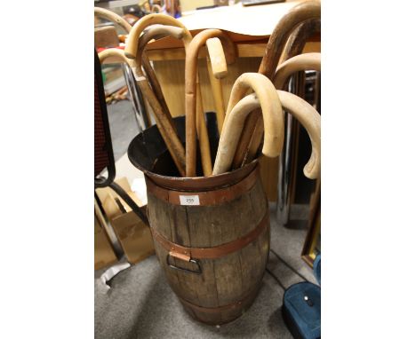 A VINTAGE METAL BANDED OAK STICK STAND AND CONTENTS 