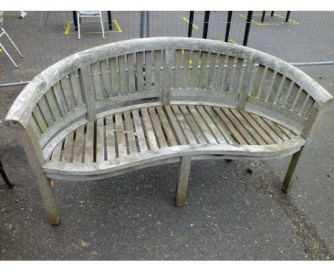 A CURVED BACK WOODEN GARDEN BENCH