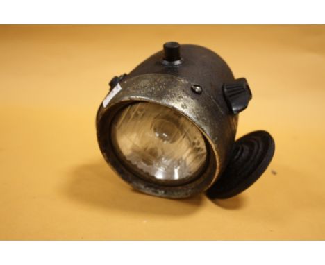 A VINTAGE MOTORCYCLE HEADLAMP WITH TAX DISK BY LUCAS 