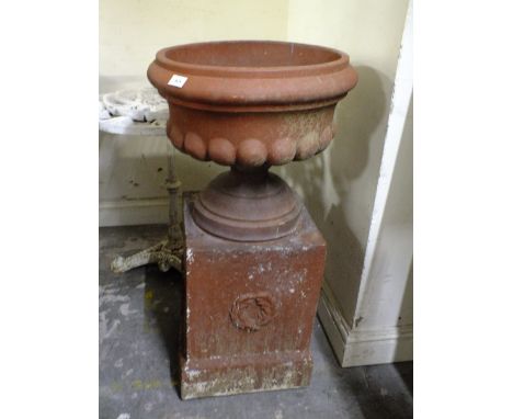 A LARGE TERRACOTTA PLANTER ON BASE