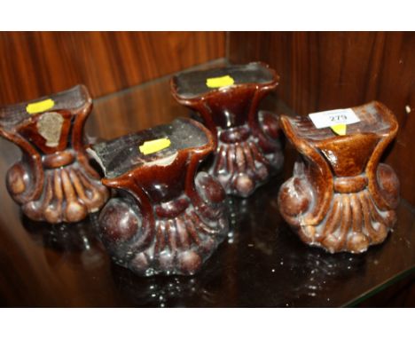 A SET OF FOUR ANTIQUE CERAMIC FURNITURE FEET A/F 