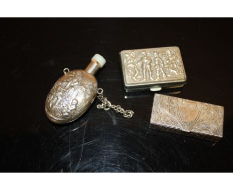 A CHERUBIC WHITE METAL SNUFF BOTTLE WITH JADE TYPE STOPPER, TOGETHER WITH A WHITE METAL SNUFF BOX AND A PILL BOX (3) 
