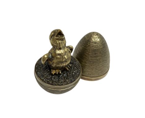 Stuart Devlin (Australian 1931-2018): Silver-gilt egg containing a silver-gilt chick with open beak standing on oxidised stra