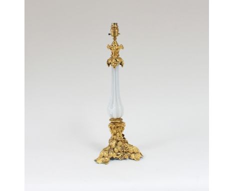 A gilt metal and opaque glass table lamp, the central ribbed white opaque glass stem supported with metal mounts cast with vi