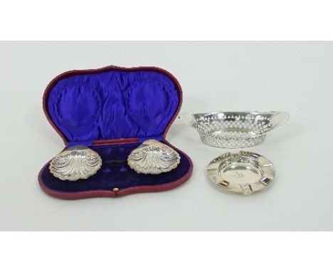 A silver boat-shaped basket, H A, Sheffield 1898, a pair of shell-shaped butter dishes, London 1908 and a silver ashtray with