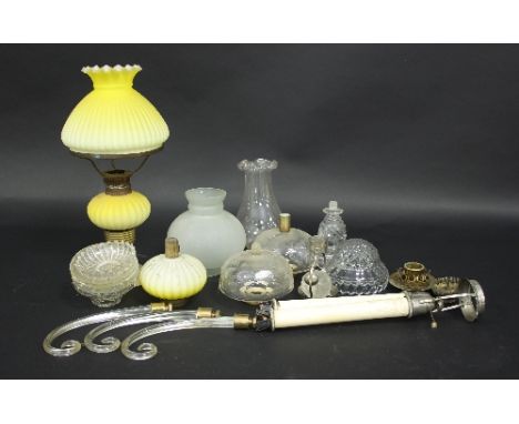 A Victorian glass oil lamp with ribbed yellow Burmese glass shade and well, a matching well, various glass shades, wells, etc
