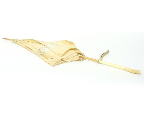 A Japanese parasol, circa 1900, the ivory handle carved a monkey and vines, with bamboo stick and cream silk parasol embroide