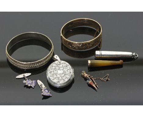 A Scottish hardstone brooch modelled as a dirk and set in 9ct gold, an oval silver locket, a cigarette holder in a silver cas