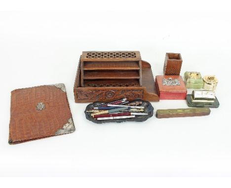 A small group of desk related items to include a carved wood letter rack, an onyx desk lighter, a crocodile skin and silver m