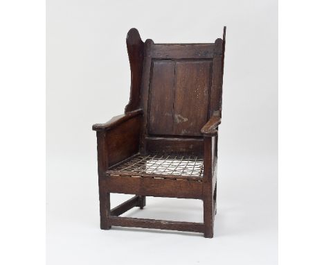 An 18th Century oak lambing chair with wing back and strung seat, 96cm high Condition Report: Right hand wing split, split to