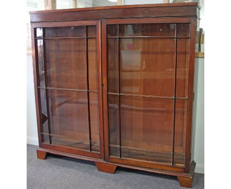 A mahogany bookcase enclosed by twin glazed panel doors, 166.5cm wide