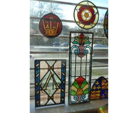 Five various panels of stained glass comprising a tall rectangular floral motif panel, another initialled 'EP', a circular ex
