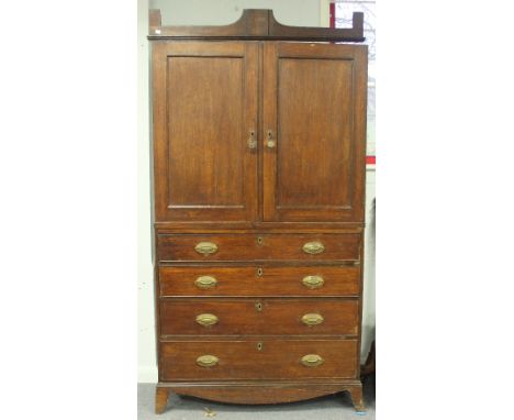 A 19th Century oak linen press, the upper section enclosed by panel doors on a chest base of four long graduated drawers, on 