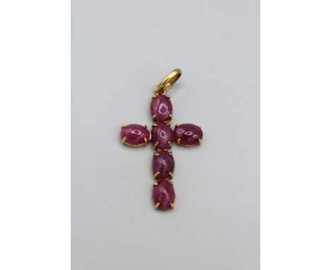  A cabochon ruby set cross, signed Paola B. Featuring six cabochons of ruby set in yellow metal stamped 750 with Italian gold